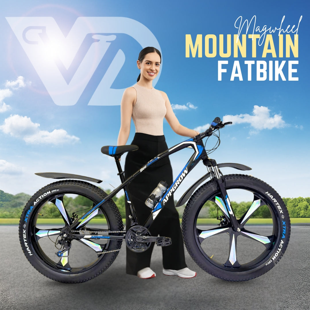 26T Appgrow Fat Jaguar black and blue mountain fatbike with mag wheels, showcased with a smiling model under clear sky.