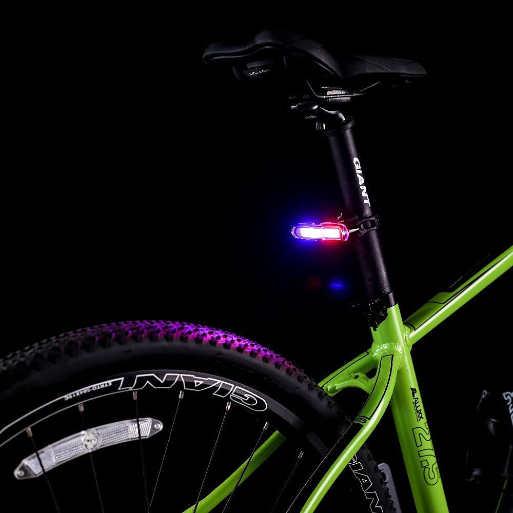 Fastped red, blue, and white LED tail light mounted on the rear of a bicycle – waterproof USB rechargeable light for night riding and visibility

